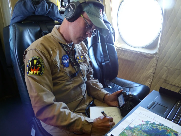 John Sonntag, Operation IceBridge mission scientist, takes notes during the science flight over Larsen C