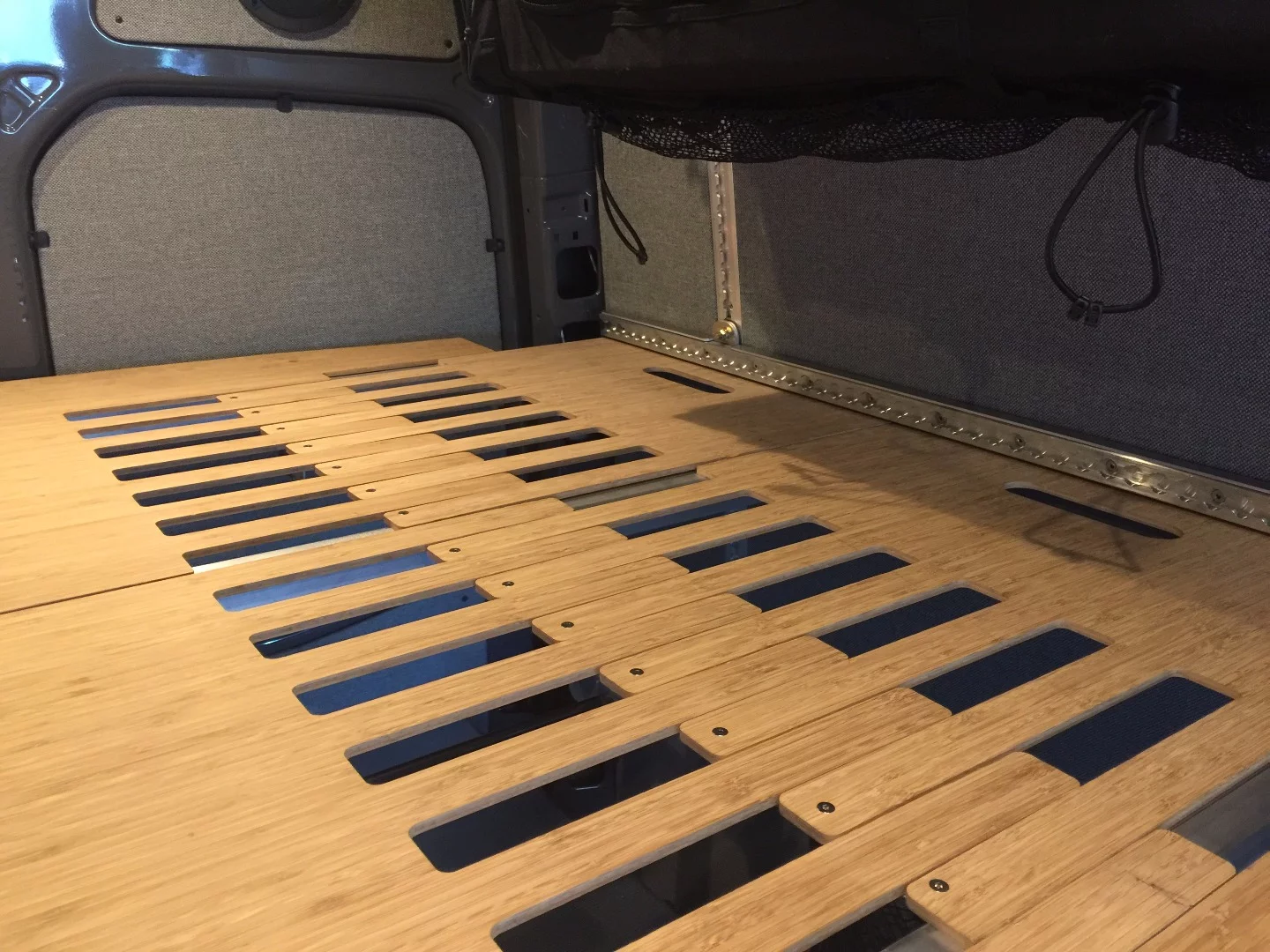 The telescoping hardware of Adventure Wagon's bed panels allows the bed to expand and contract to meet the contours of the van walls