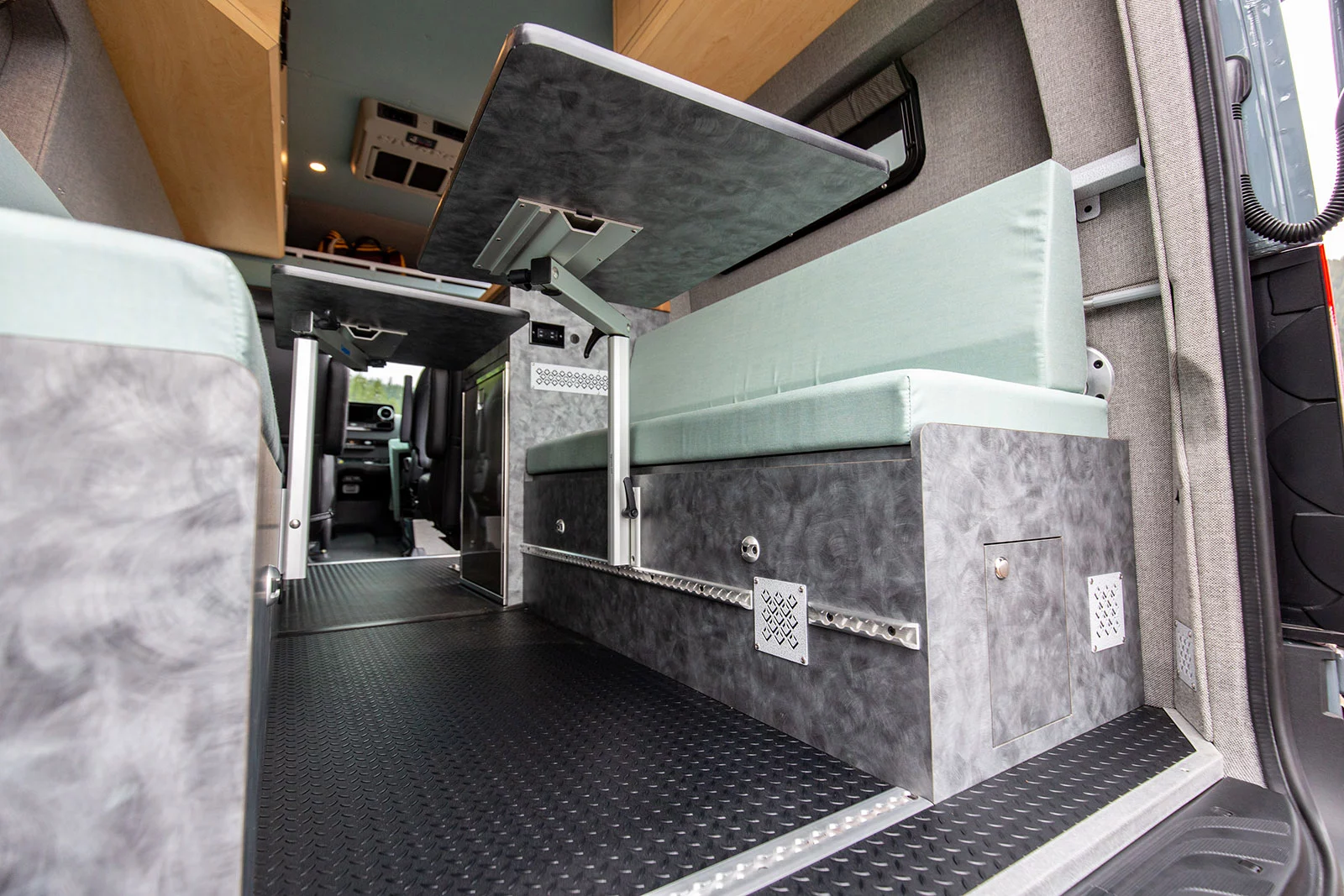 Pull the tables down and the center aisle offers space to store bikes and gear, the L-track all over working to secure everything down