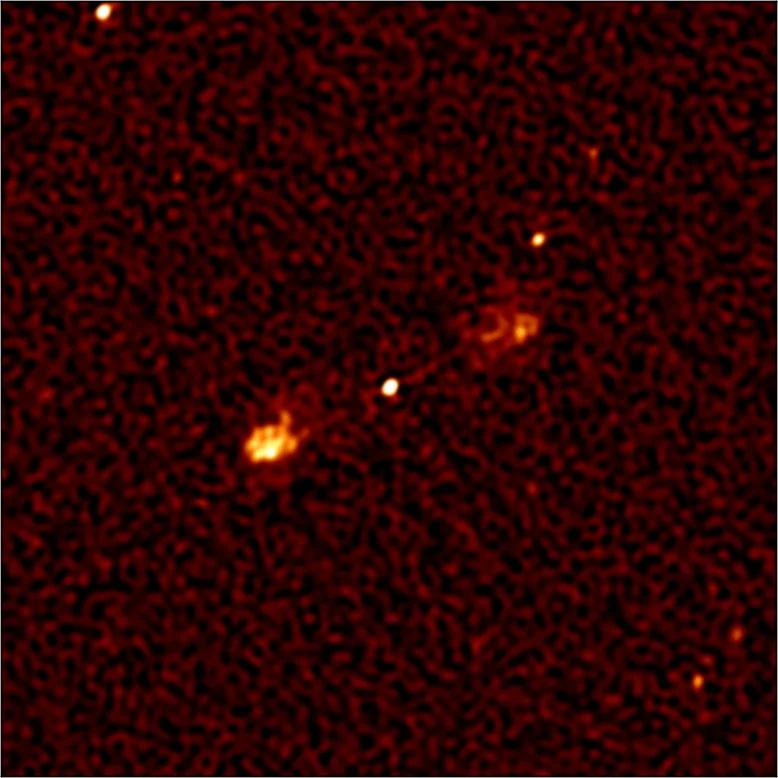 This image, which was the lower-right panel in the previous picture, shows a massive black hole at the center of a distant galaxy (bright spot in the middle), with jets of electrons spewing out in opposite directions