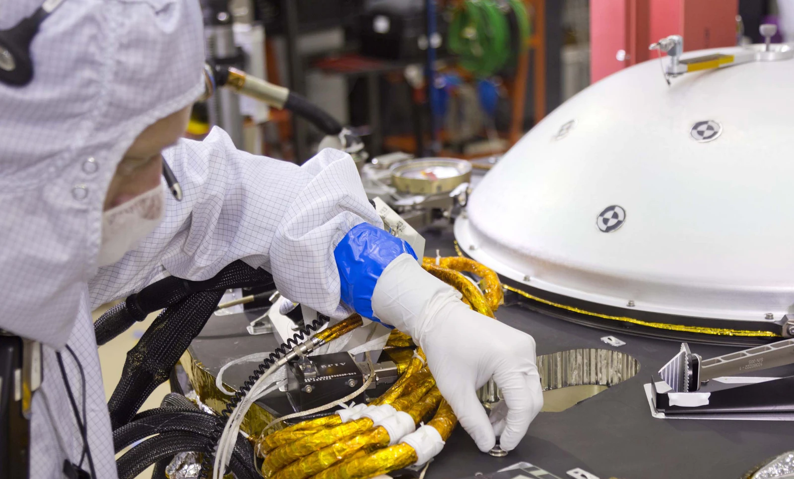 A spacecraft specialist affixes a dime-size chip onto the lander deck in November 2015