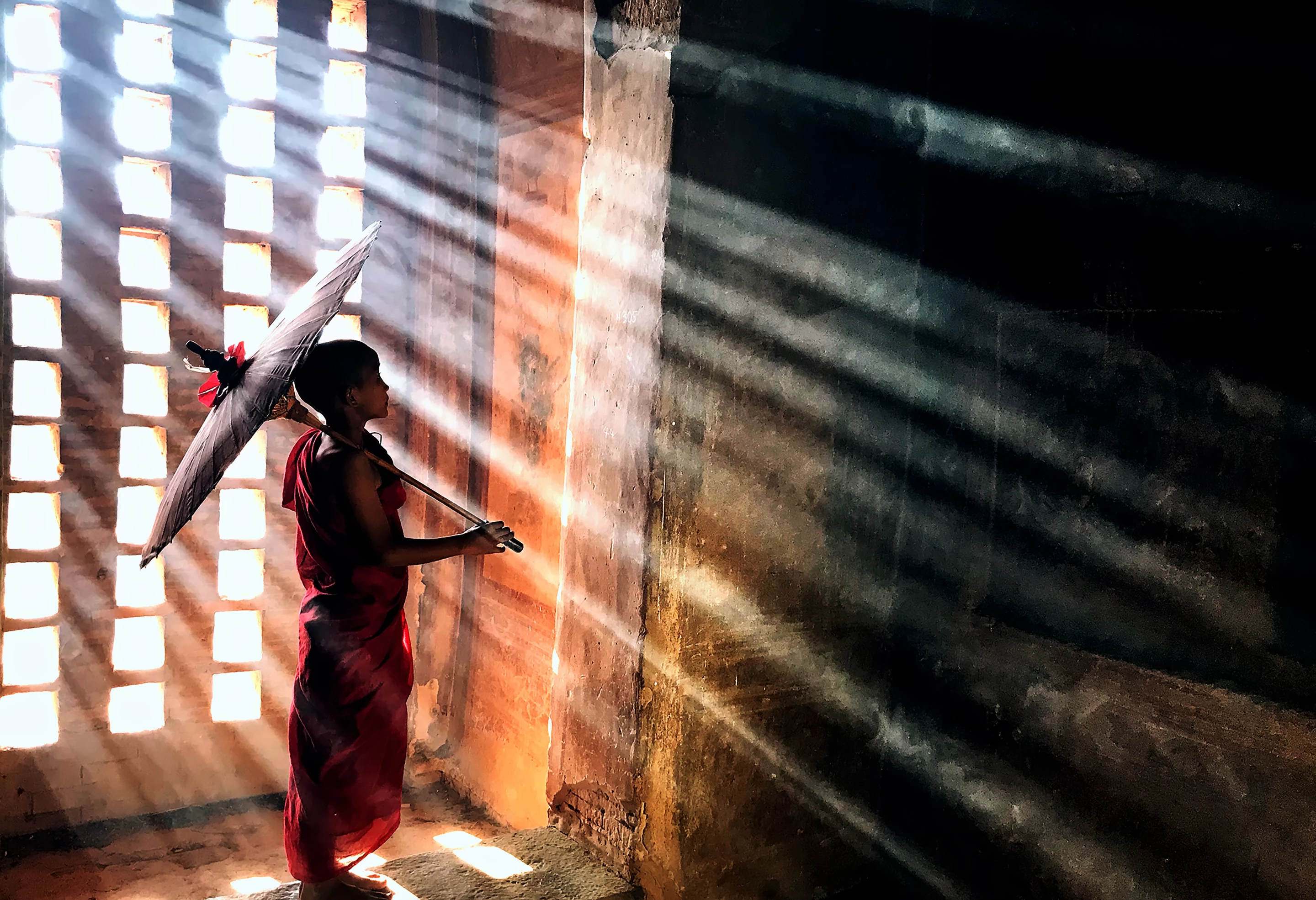 Finalist, Mobile. "Novice in the Rays of a Temple". A young novice walking in the rays of a temple in Bagan, Myanmar, learning about the historical wall-paintings of the temple