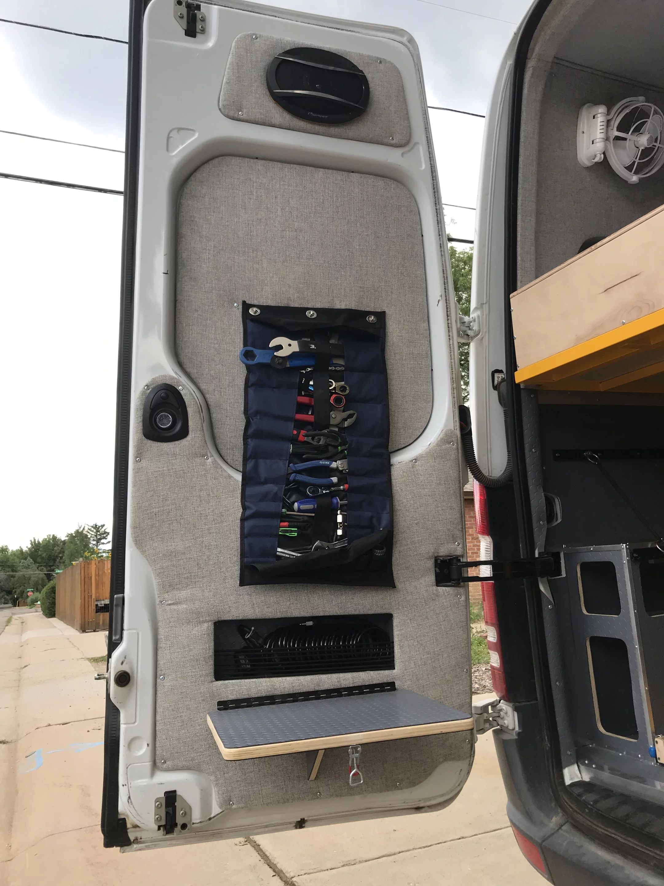 A couple of twist locks hold the tool roll on the door for easy tool access