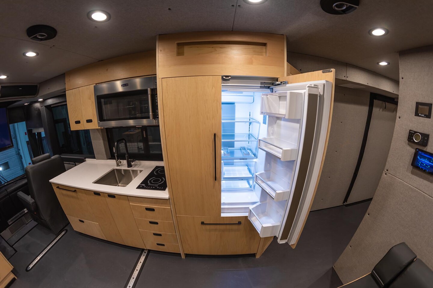 The Loki XL Coach includes a large residential-style fridge, induction cooktop, microwave and dishwasher