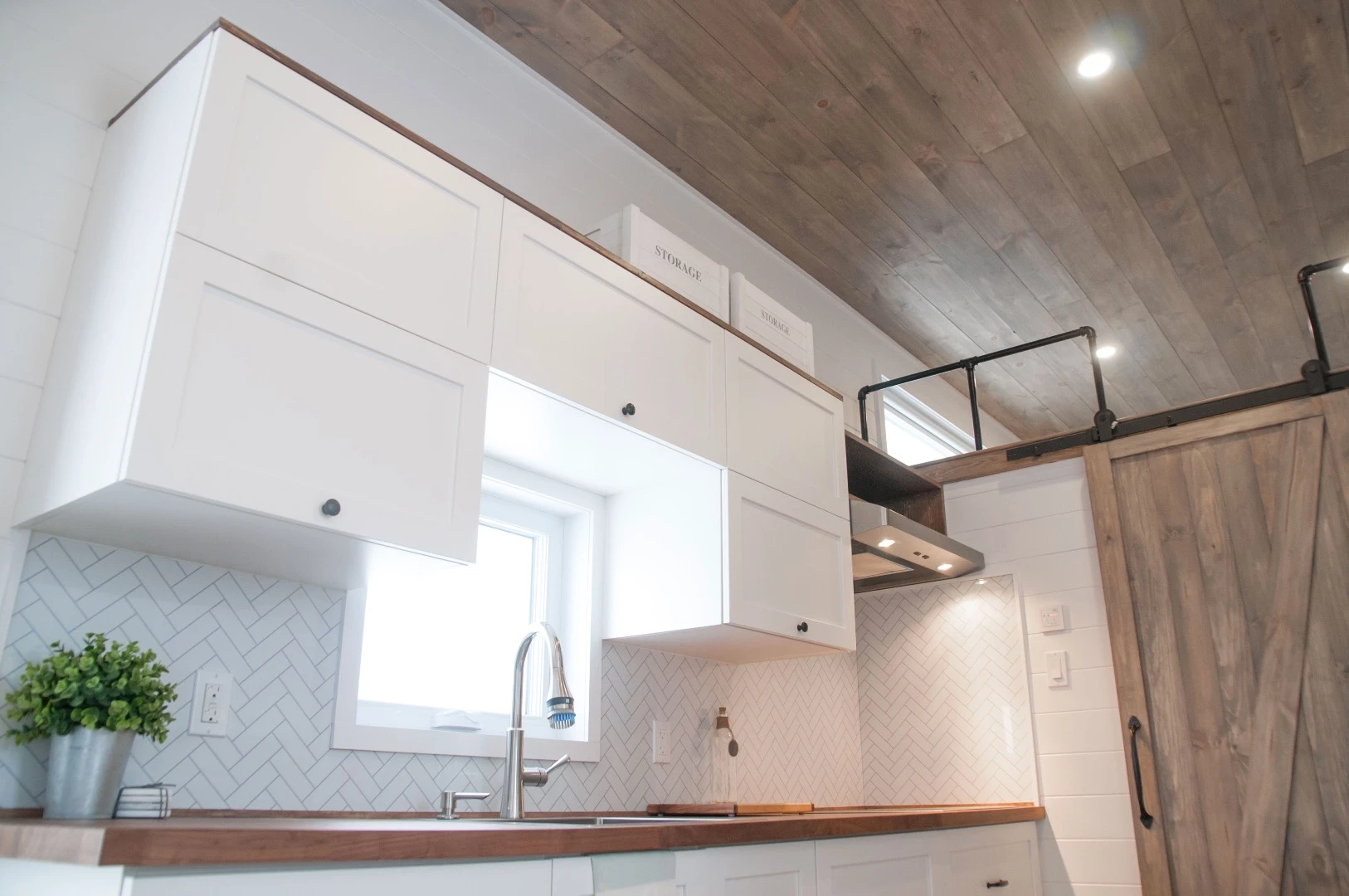 The Ébène's kitchen includes two freezers, a fridge, stainless steel sink, induction stove, and a microwave/oven