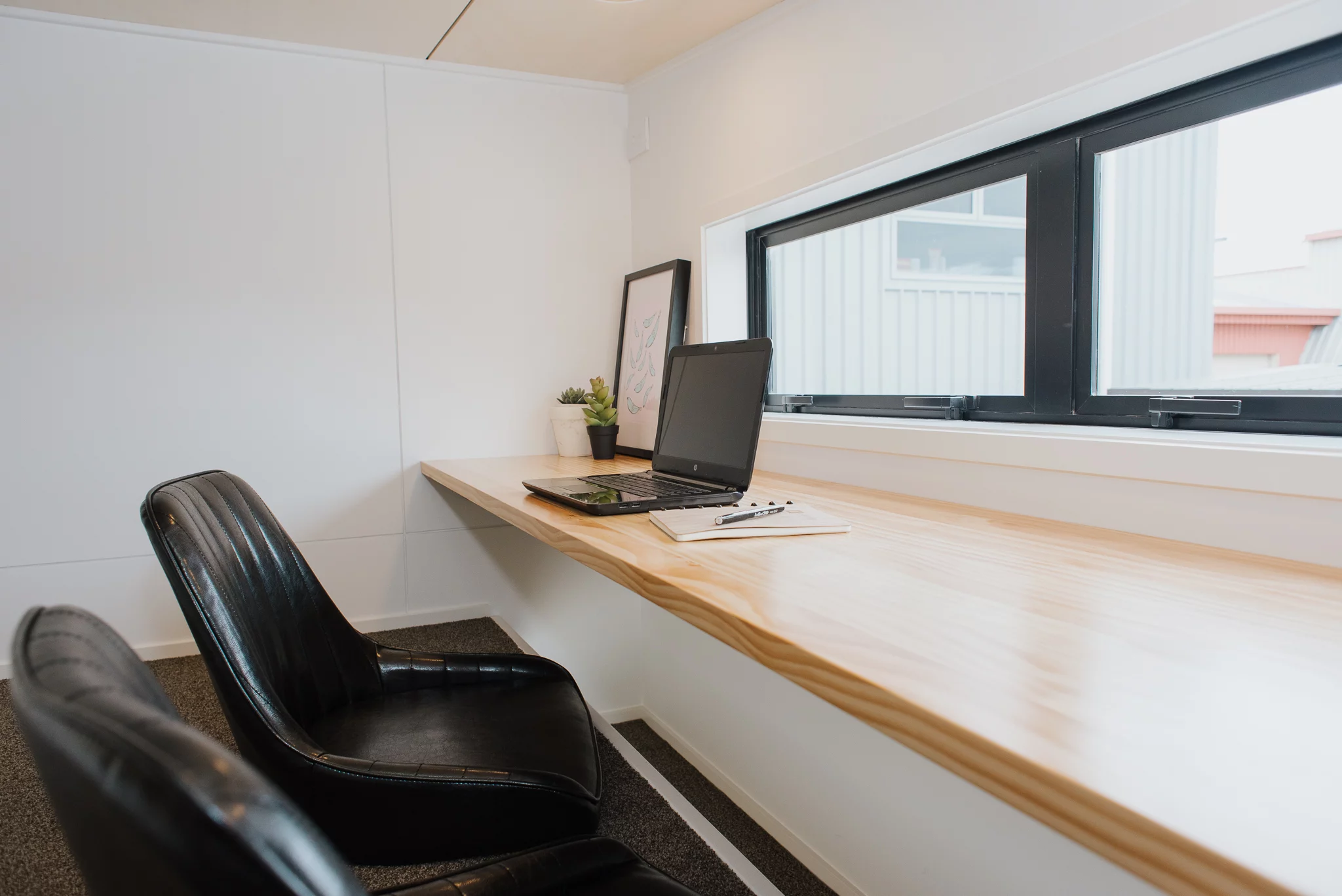 Cyril the Tiny House's office space includes a handy lowered footrest area to make it more comfortable to sit at the desk