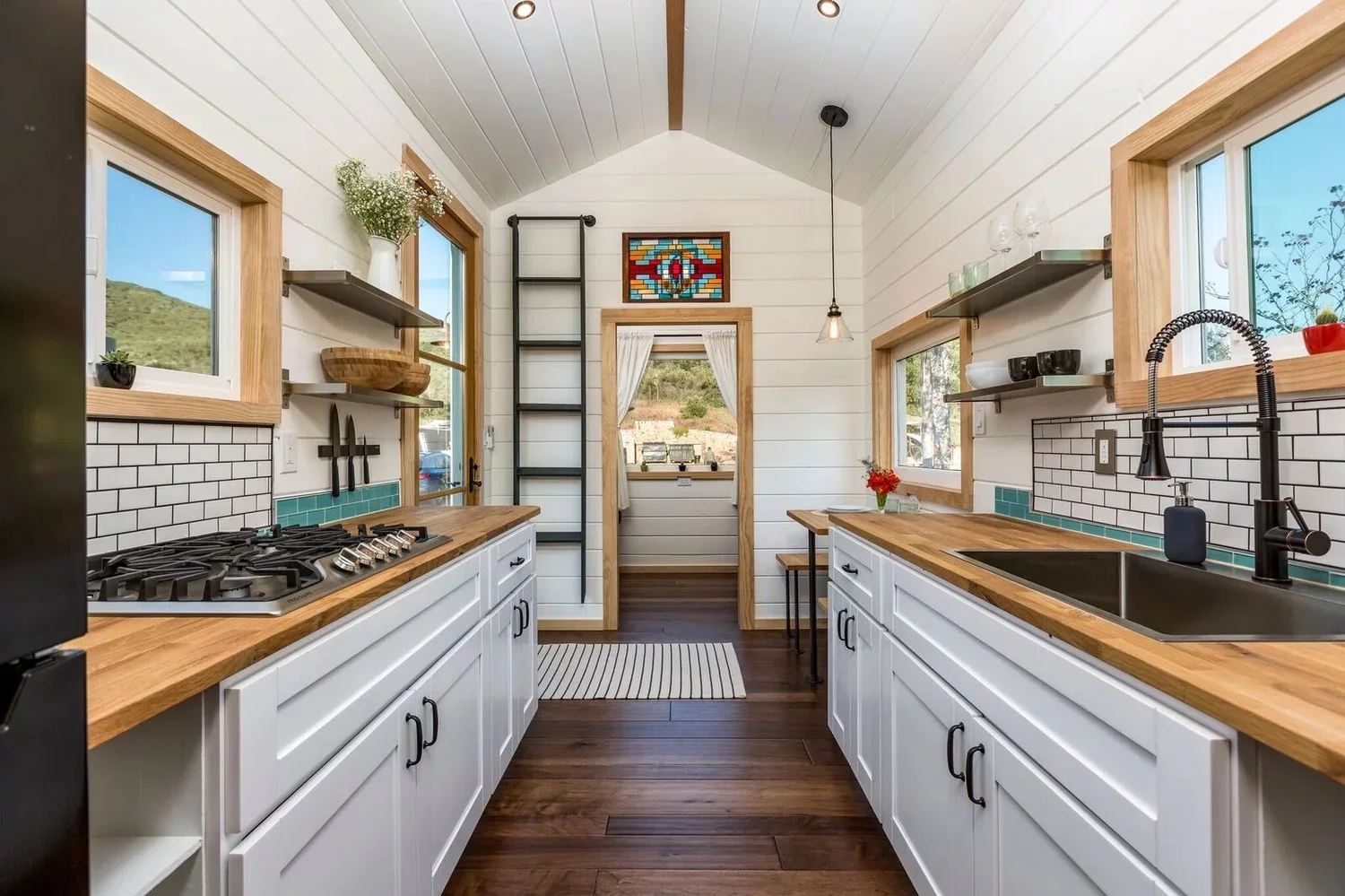 The Joshua Tree's kitchen includes a sink, four-burner propane-powered cooktop, fridge/freezer, and washer/dryer