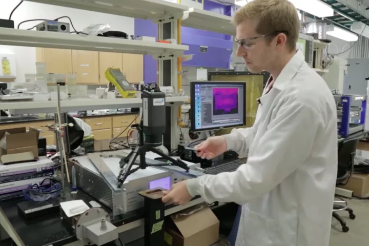 Brandon Sweeney places a 3D-printed item in the microwave source
