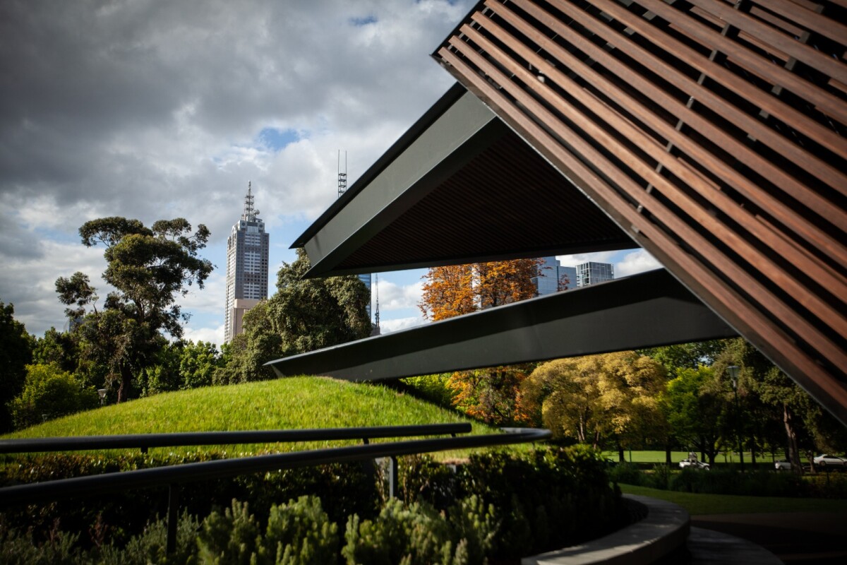 Grassy mounds surround the MPavilion and offer tiered seating, while also serving as the anchor points for the huge floating planes that make up its walls and roof