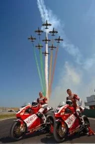 The "Frecce Tricolori" of the Acrobatic Team fly over the Troy Bayliss and Lorenzo Lanzi pose 999s