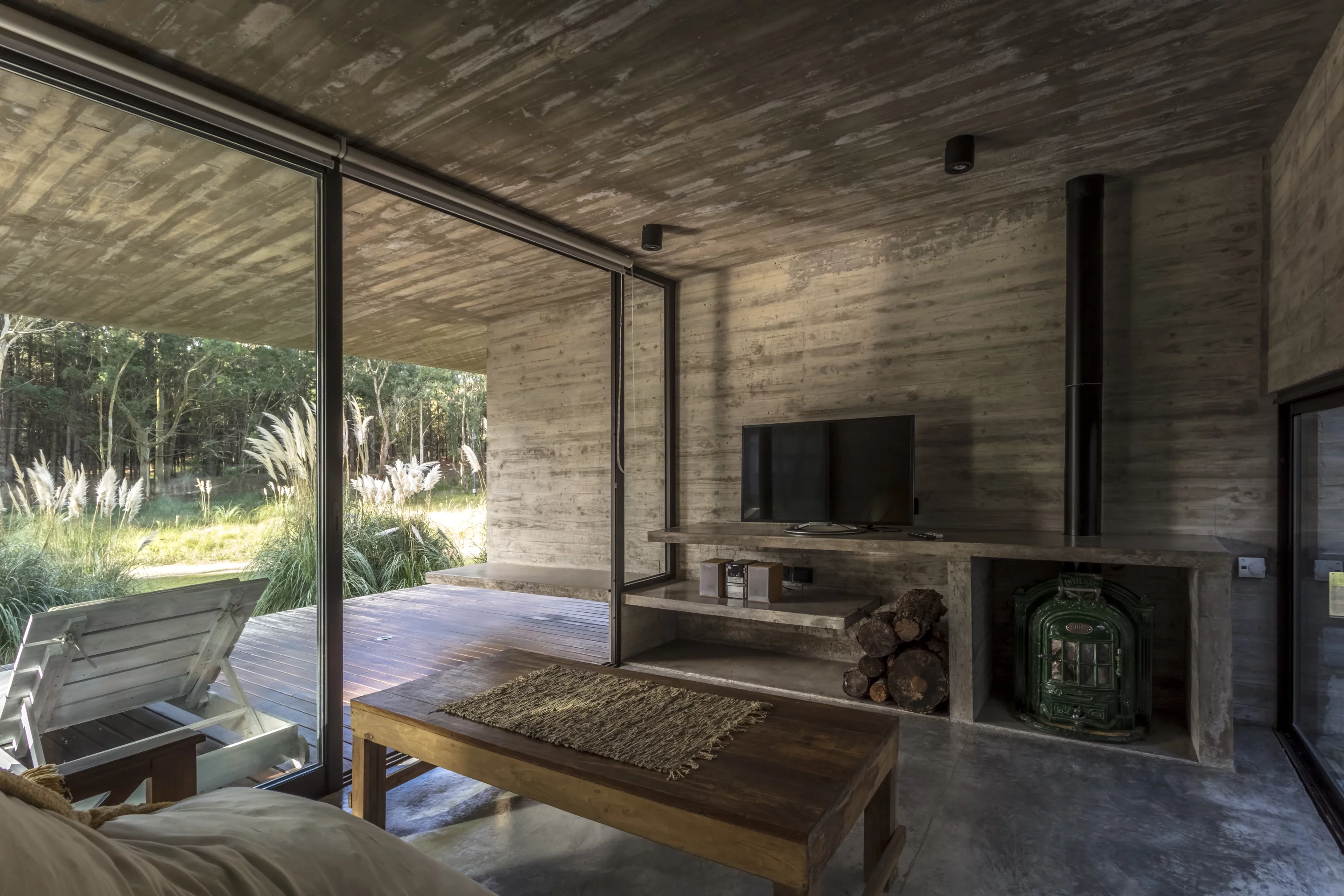 A living area opens up to a covered balcony in the Forest House, by Besonias Almeida