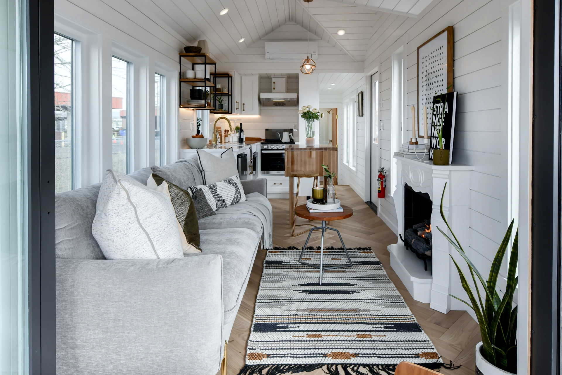 Tiny house boosts living space with motorized deck and spiral staircase