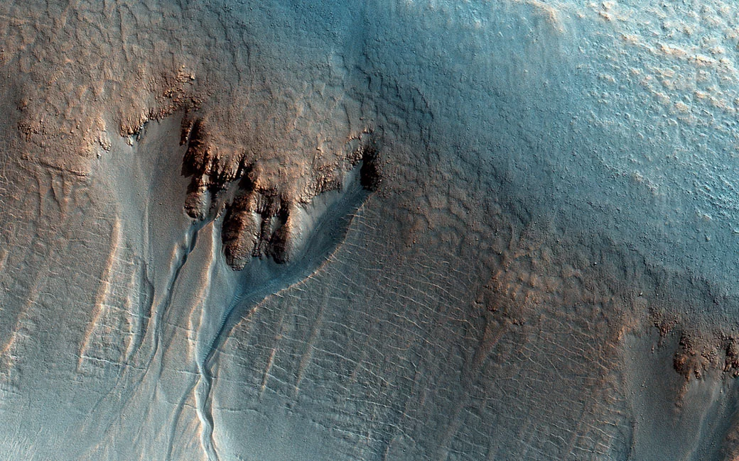The shape of the gullies in this enhanced-color image of the Utopia Planitia region hints that water was involved in their formation
