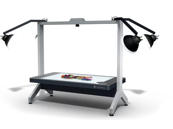 StyleShoots consists of a large glass light table, overhead daylight simulation lamps, an integrated Mac mini, an iPad and a Canon 5D Mark II camera