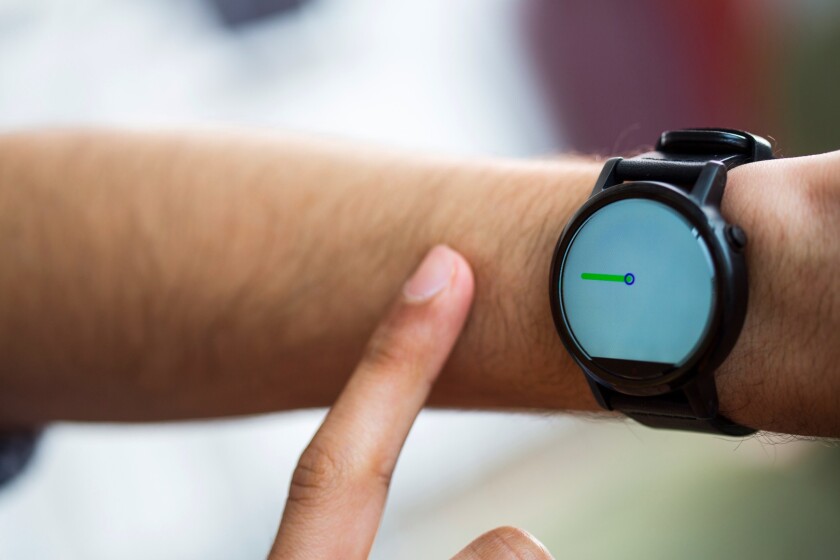 A FingerIO-equipped smartwatch tracks a user's finger as it draws a line on their arm