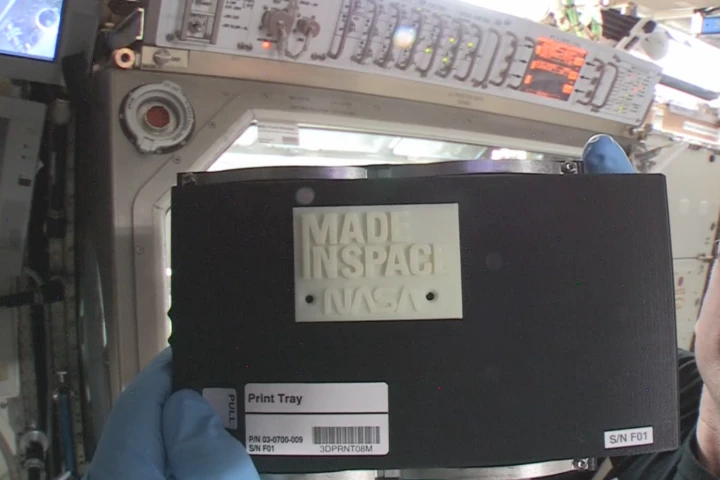 International Space Station Commander Barry “Butch” Wilmore with the first object made in space by 3D printing (Image: NASA)