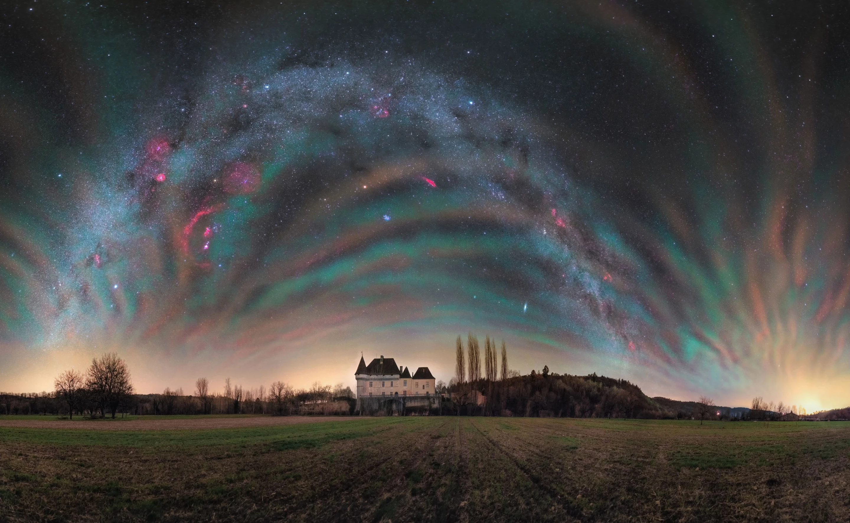 Atmospheric fireworks by Julien Looten, taken in France. The Milky Way fights for attention in this 180-degree panorama, against a charming medieval castle and a phenomenon known as chemiluminescence, which creates an effect like