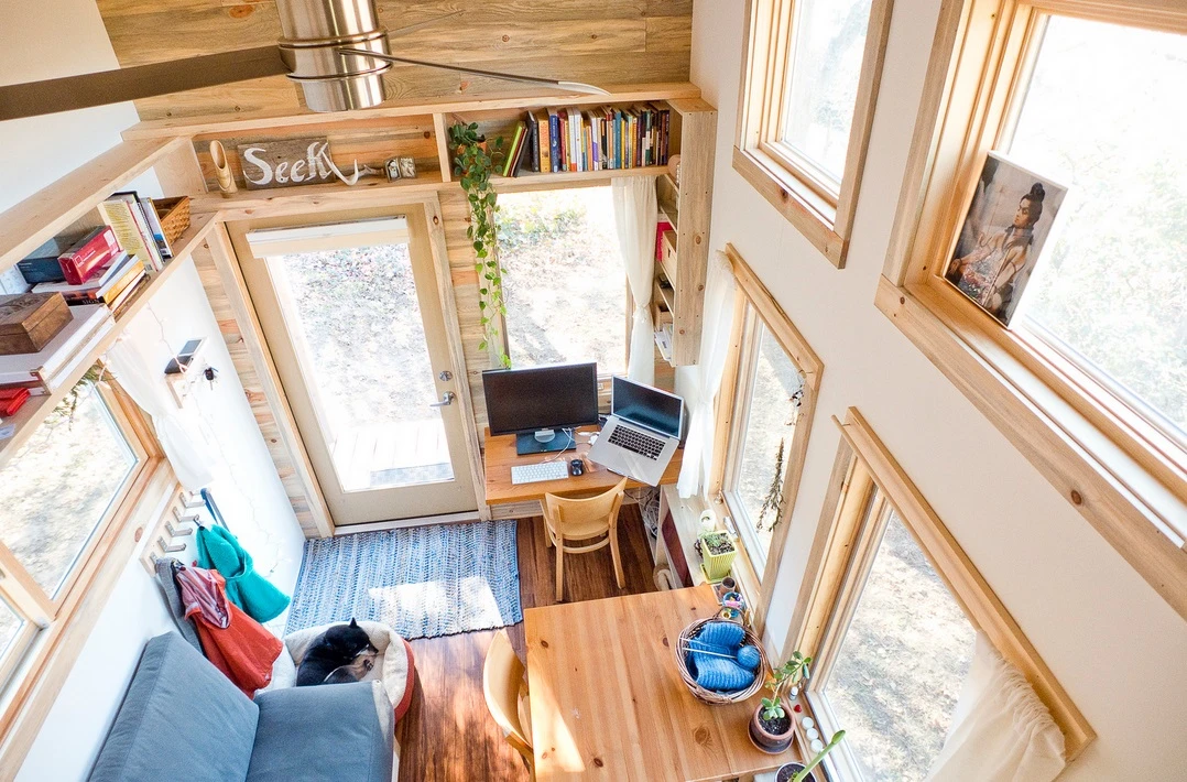 The interior of the micro home consists of a main living area with high ceilings, elevated loft bedroom, mini kitchen and bathroom