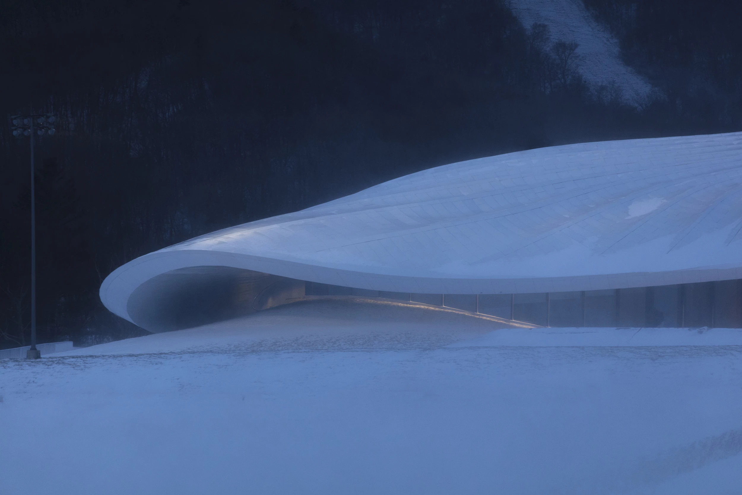 "Nestled among Yabuli’s mountainous terrain, MAD’s scheme evokes the concept of a tent sitting at the foot of a mountain, with its soft, curving, silver-white rooftop echoing the snow-capped hills surrounding it," says MAD
