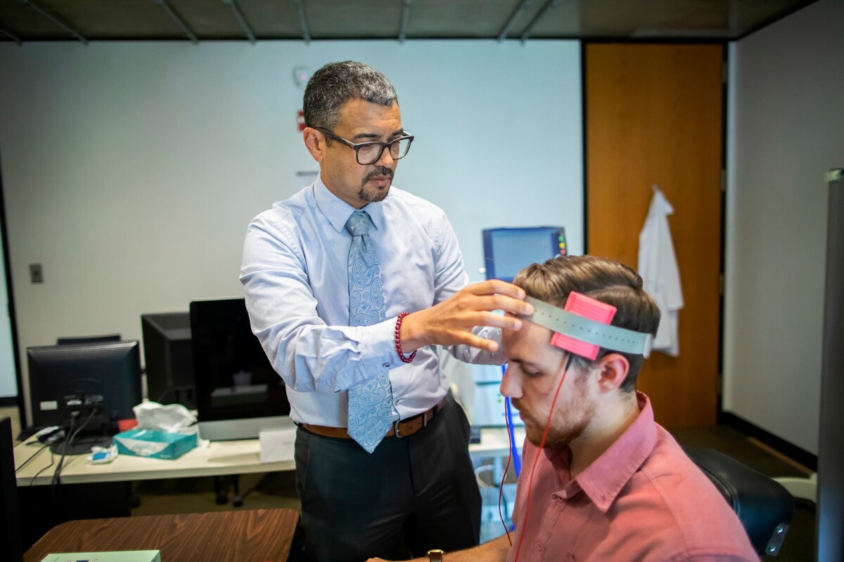 Roy Hamilton of Penn Medicine was part of a research team that studied whether a minimally invasive brain stimulation, similar to what he’s demonstrating in this photo, can reduce someone’s intent to commit a violent crime