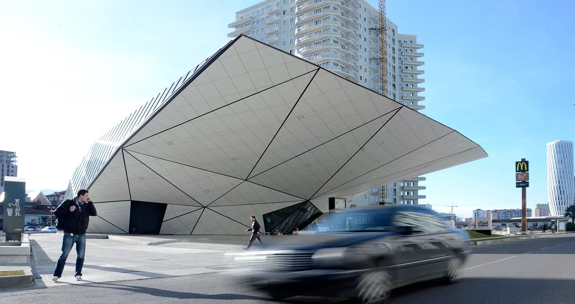 Part of the structure dramatically overhangs over the fuel station, providing shelter for its users