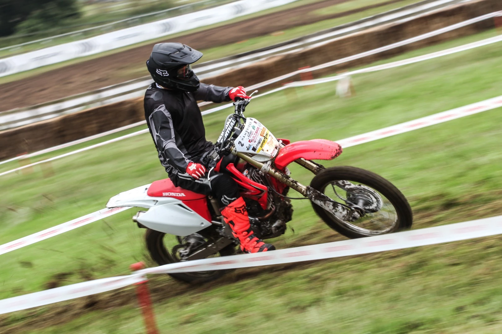 A muddy Honda having some fun in the fields at Goodwood