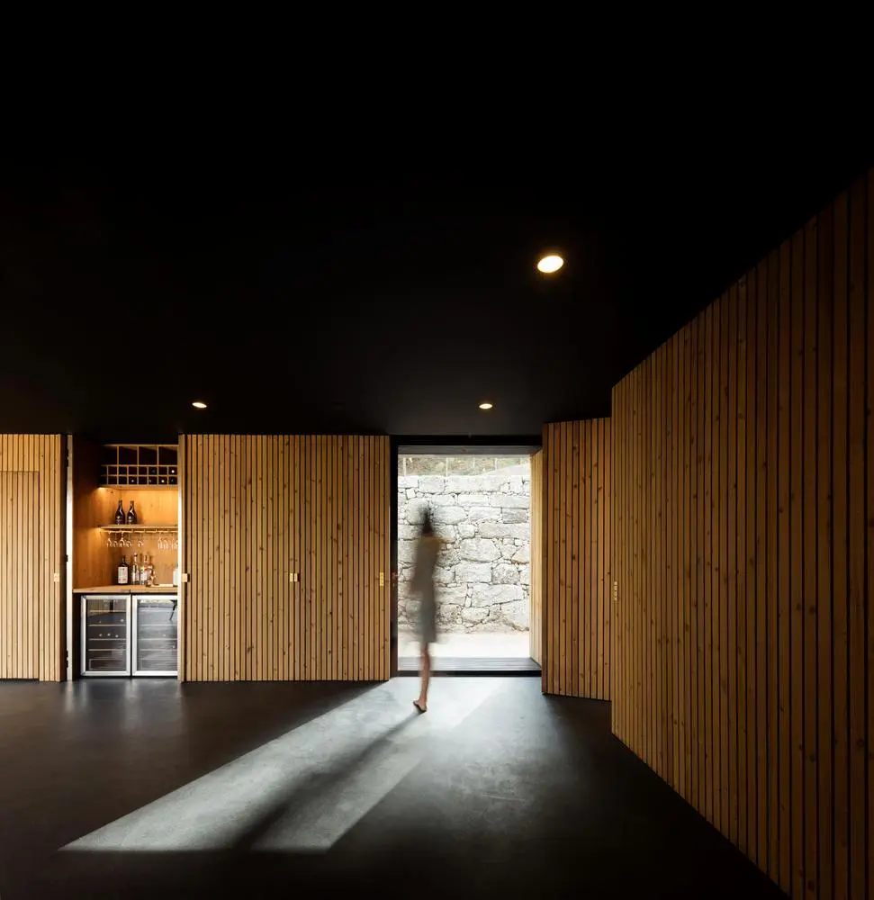 The design of the 75-sq m dwelling maximizes the open interior space, by hiding many of the home's functions and storage within the walls