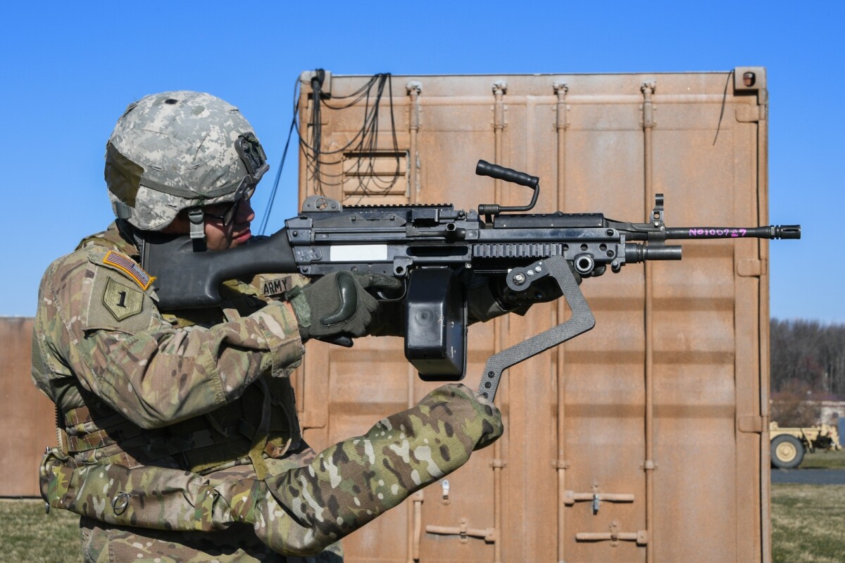 Army Sgt. Michael Zamora uses a prototype Third Arm exoskeleton to aim an 18-lb M249 light machine gun