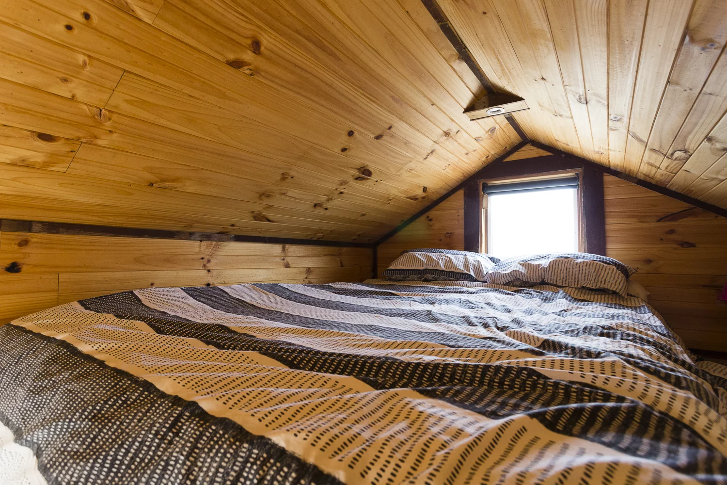 The Tallarook Hilltop Tiny House 1's bedroom is a typical loft model with a low ceiling