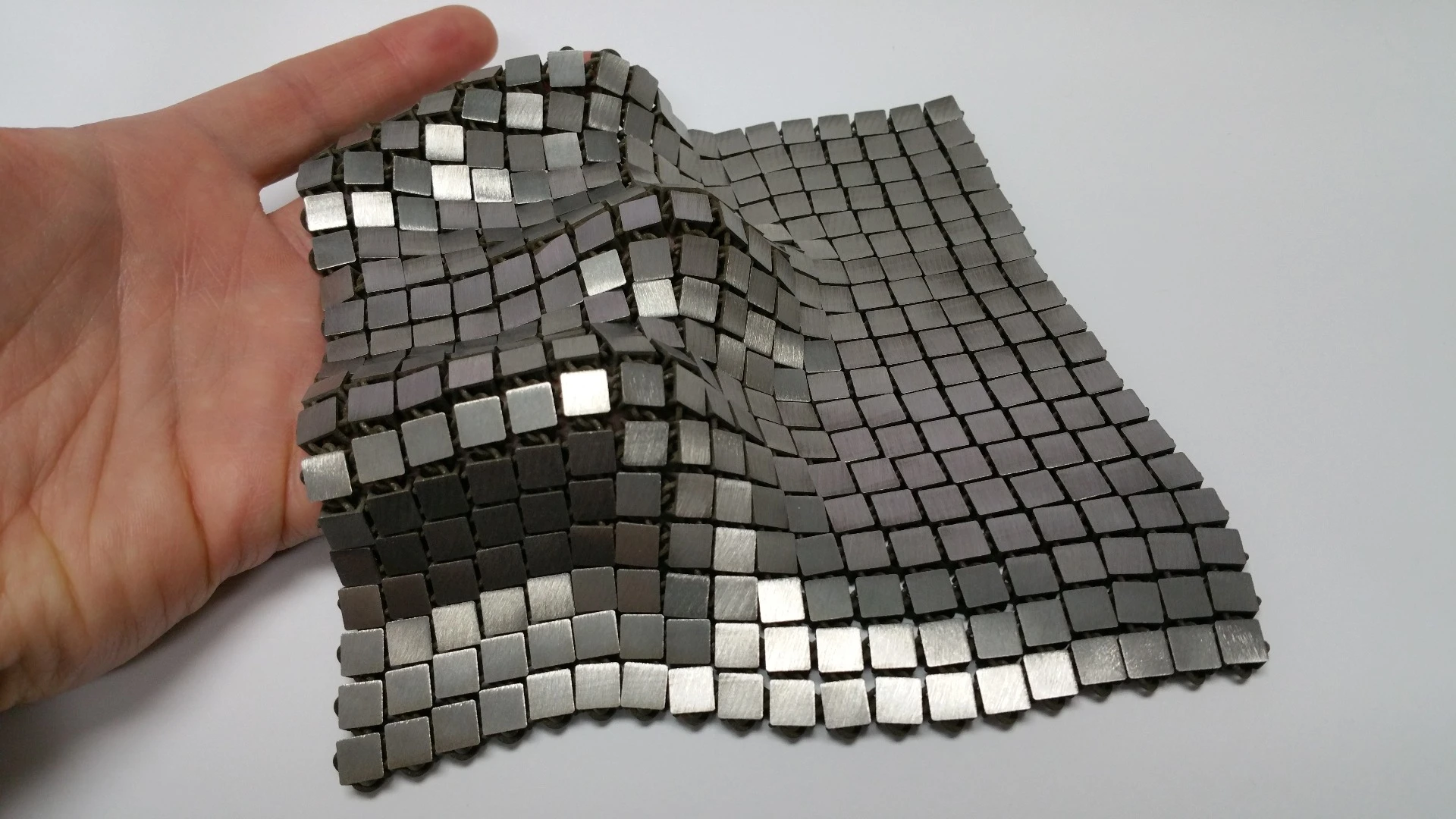 The metallic "space fabric" that was created using 3-D printing techniques that allow different functionality to be integrated into each side of the material