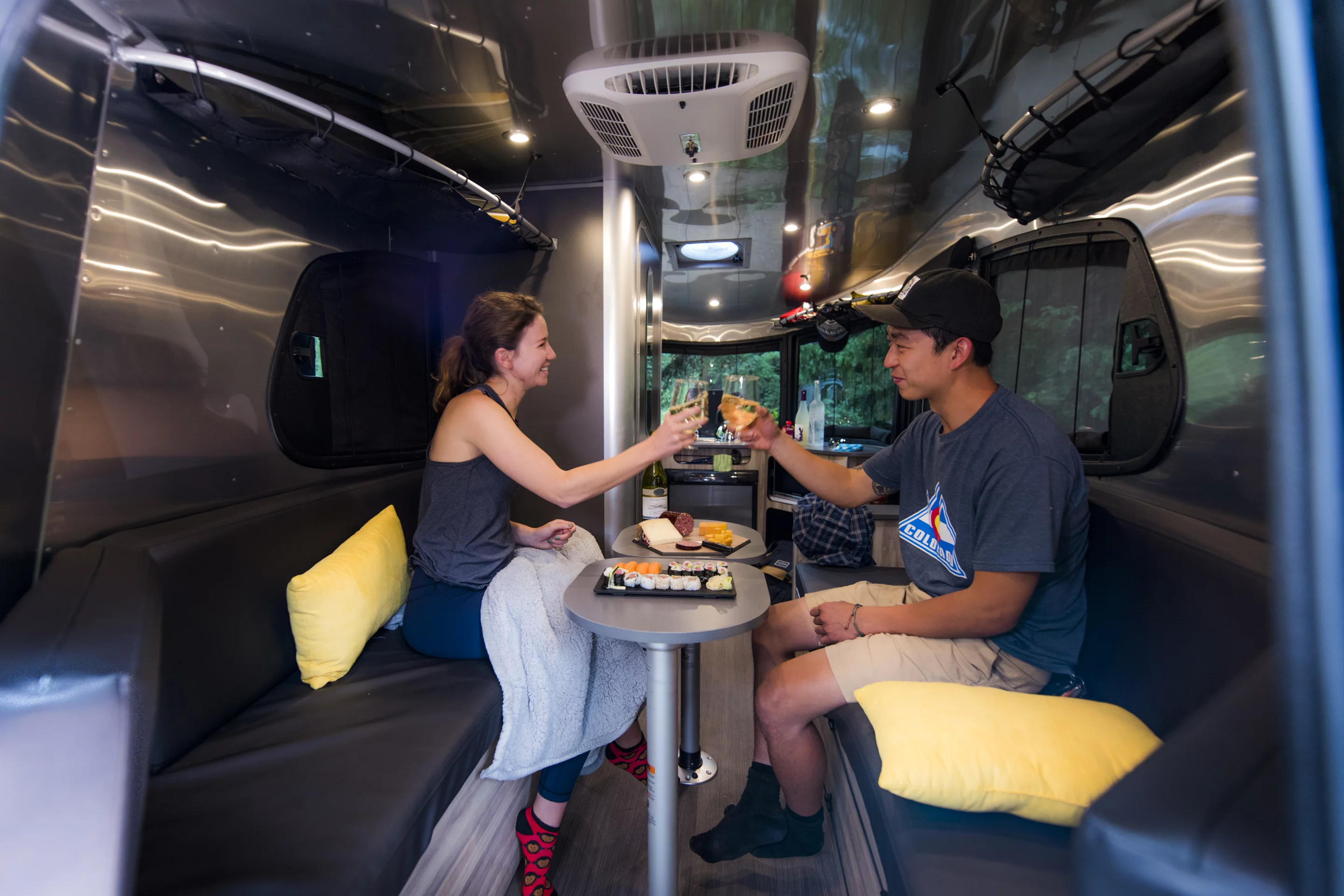 The interior living area includes two adjustable, removable tables