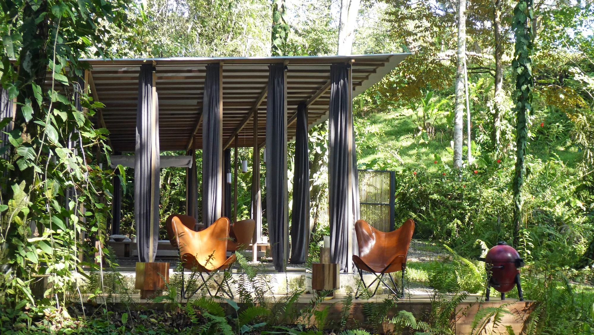 The Open Jungle House's lightweight roof is supported by slender wooden columns and beams