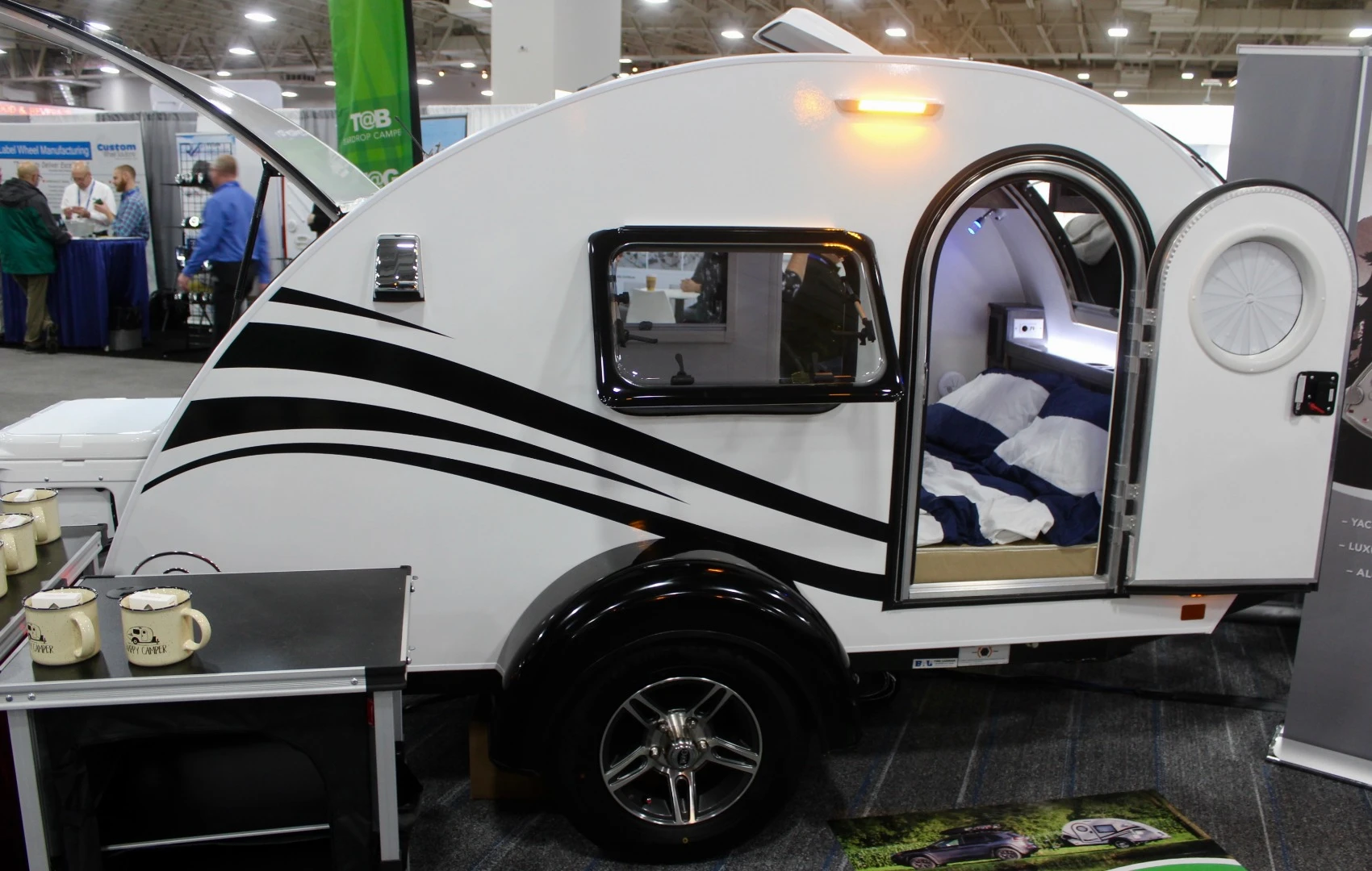 While they're both teardrops offered by nuCamp, the T@b trailer has a larger standing-height cabin with full indoor amenities, whereas the Tag (pictured) has the classic layout of compact, mattress-filled cabin and tailgate galley. NuCamp distinguishes the two by calling the T@b a "camper" and the Tag a "trailer"