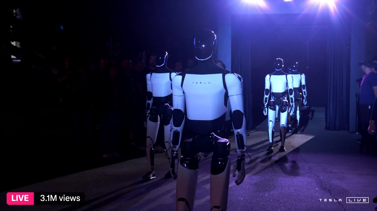 Optimus humanoids march out to serve drinks and interact with the audience at Tesla's Cybercab / Robovan launch