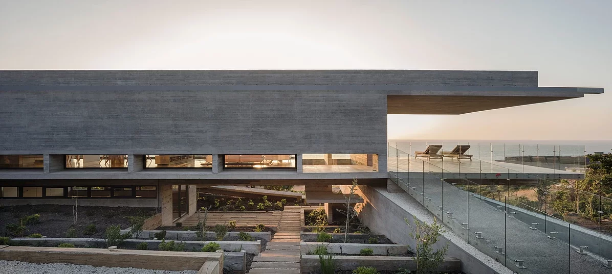 La Casa H is built into hills around the coastal town of Zapallar, leaning on a set of four monster reinforced concrete beams running the length of the structure