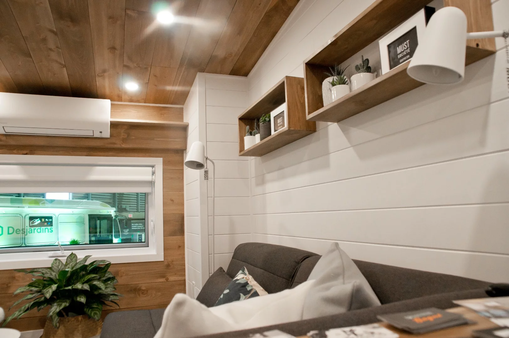 The Noyer's living room includes shelving and a small air-conditioning unit that helps keep the interior a comfortable temperature