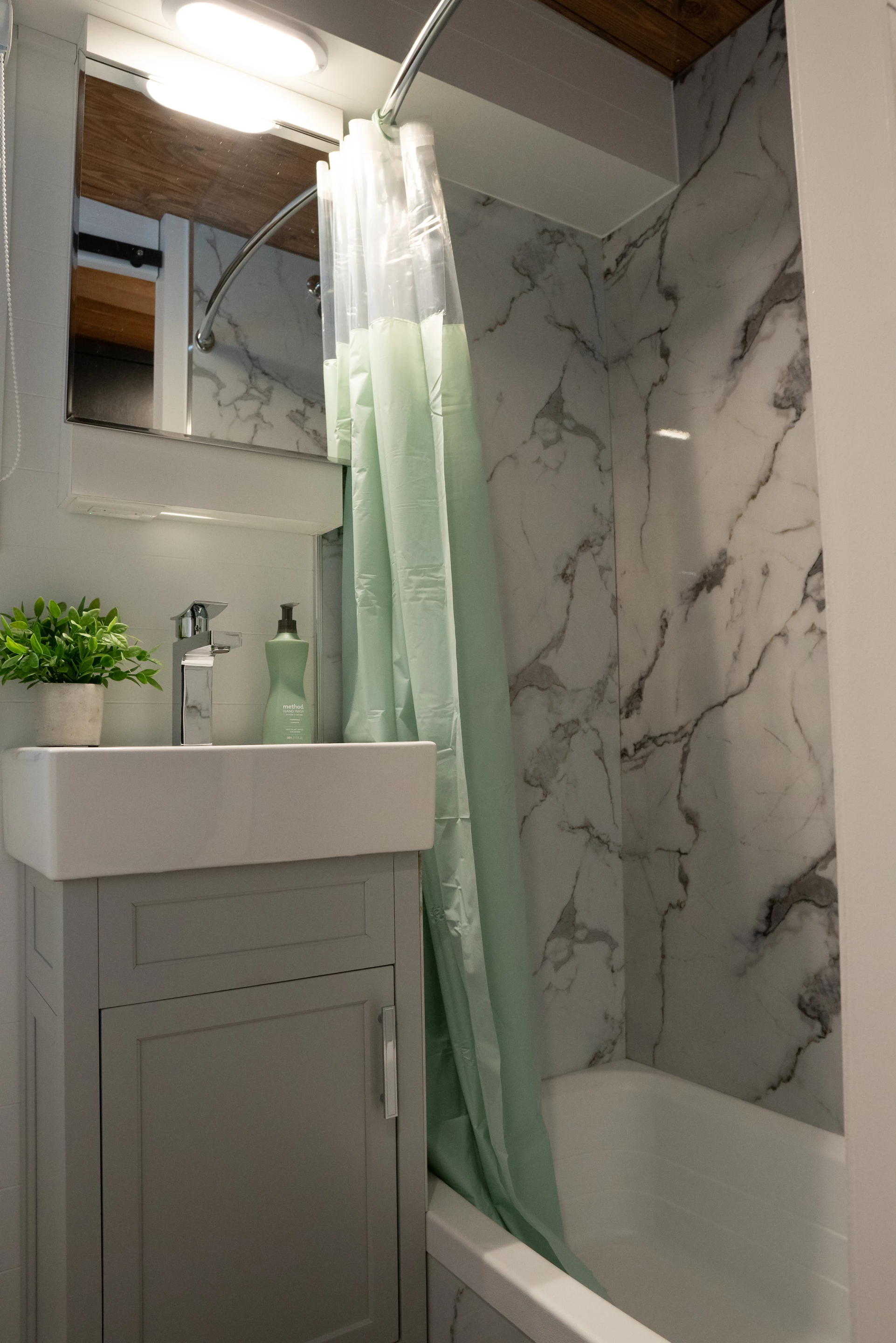 The Nomad 5th Wheel's bathroom includes a sink and a small bathtub with shower