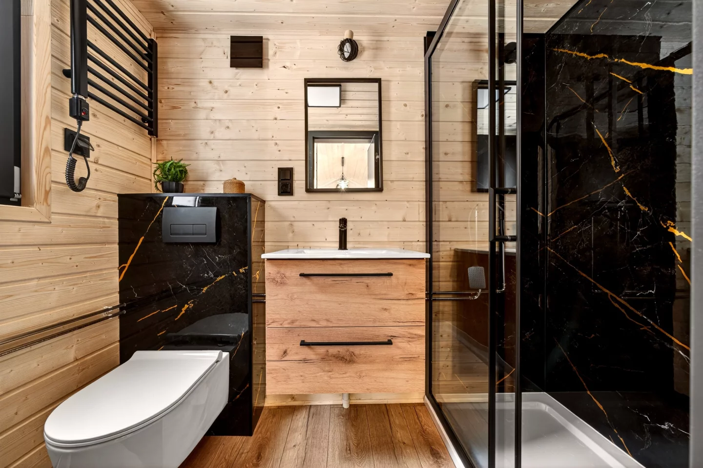 The Justine's bathroom contains a glass-enclosed shower, a flushing toilet, and a sink