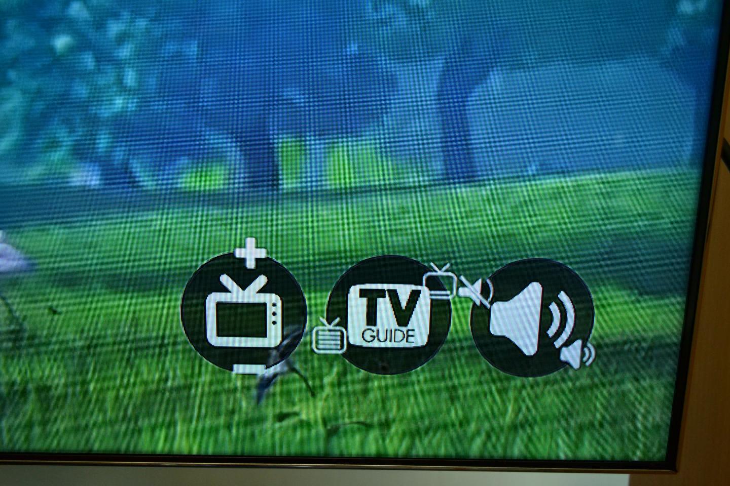 In one corner of the TV screen, there are a group of small circular widgets representing functions such as volume control or channel-changing
