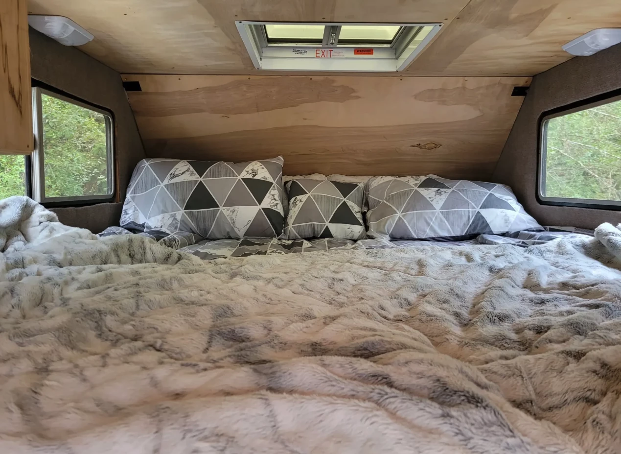 The Backwoods Camper sleeps a couple and maybe a child on a large cozy alcove bed