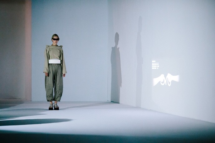 Models at Paris Fashion Week demonstrate the outfit, with their moods projected up on the wall