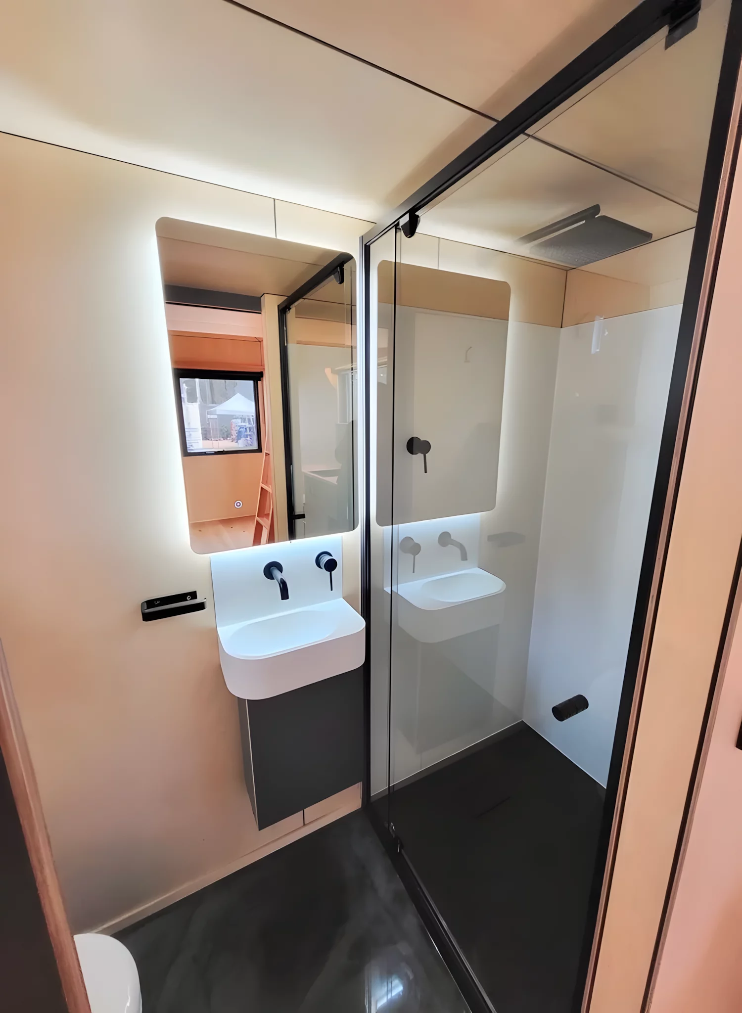 The Gunyah Modern's bathroom includes a small sink, toilet, and a shower