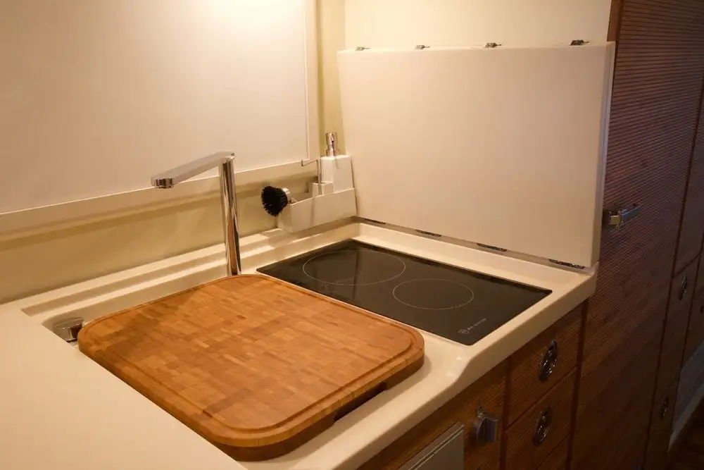 Unicat has expanded upon the idea of stove and sink lids, making a full-length countertop that covers the entire kitchen block and folds out of the way for stove/sink access