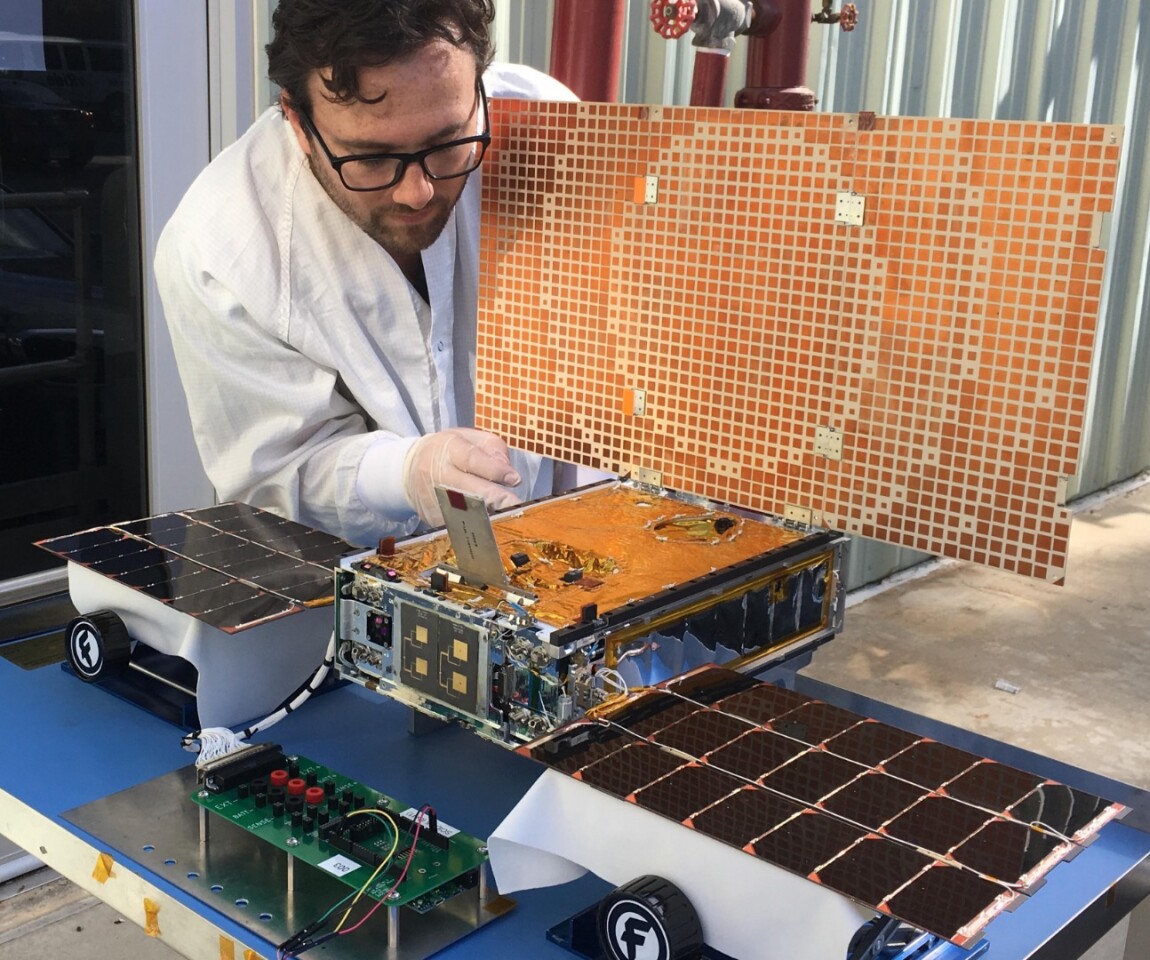 Engineer Joel Steinkraus uses sunlight to test the solar arrays on one of the Mars Cube One (MarCO) spacecraft