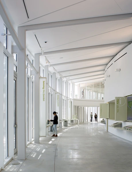 Dramatic floor-to-ceiling curved glass walls open out into the surrounding parkland and themed gardens