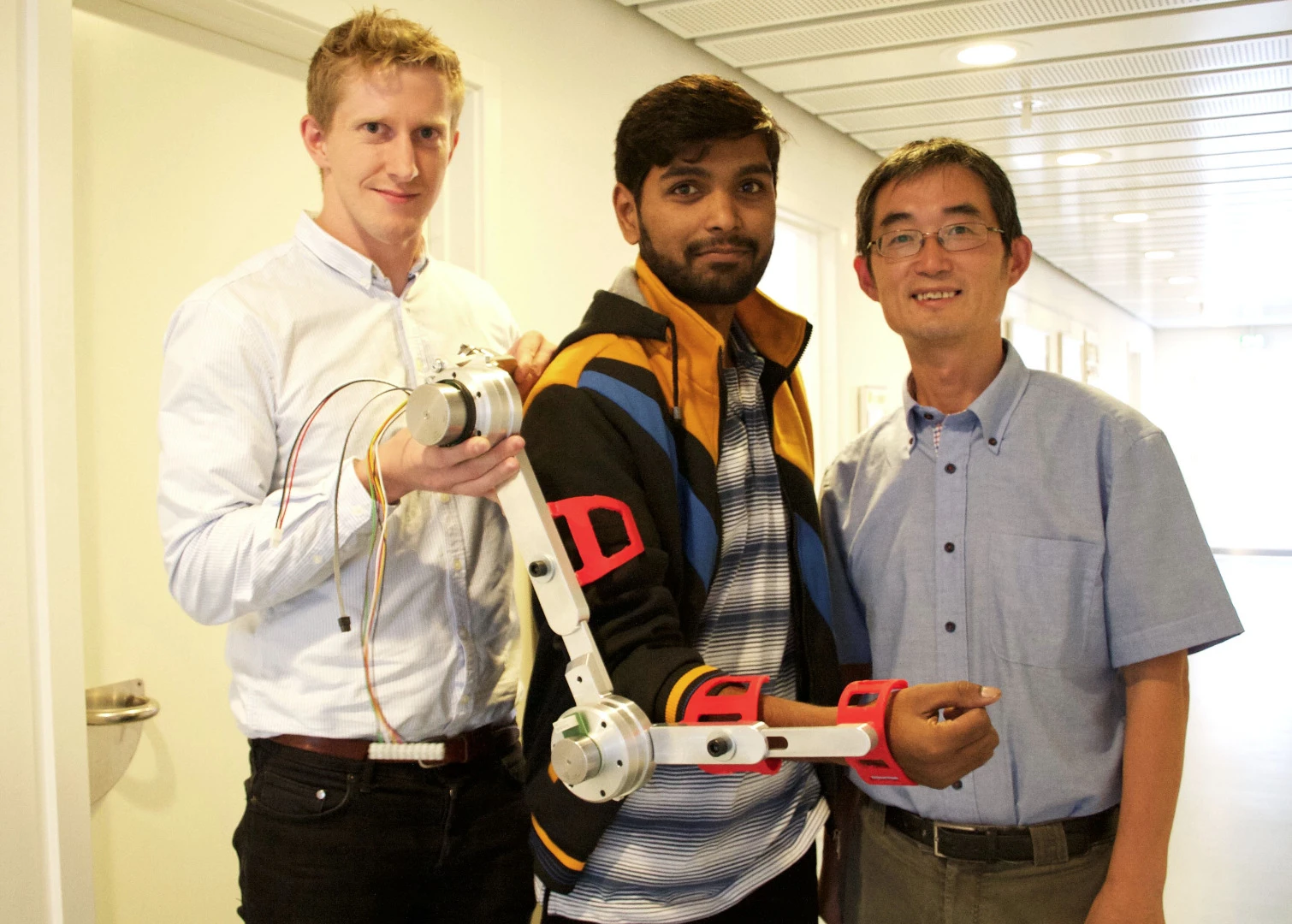 Aalborg University researchers Simon Christensen (left), Muhammad Raza Ul Islam and Shaoping Bai, with an arm brace designed for the AXO Suit