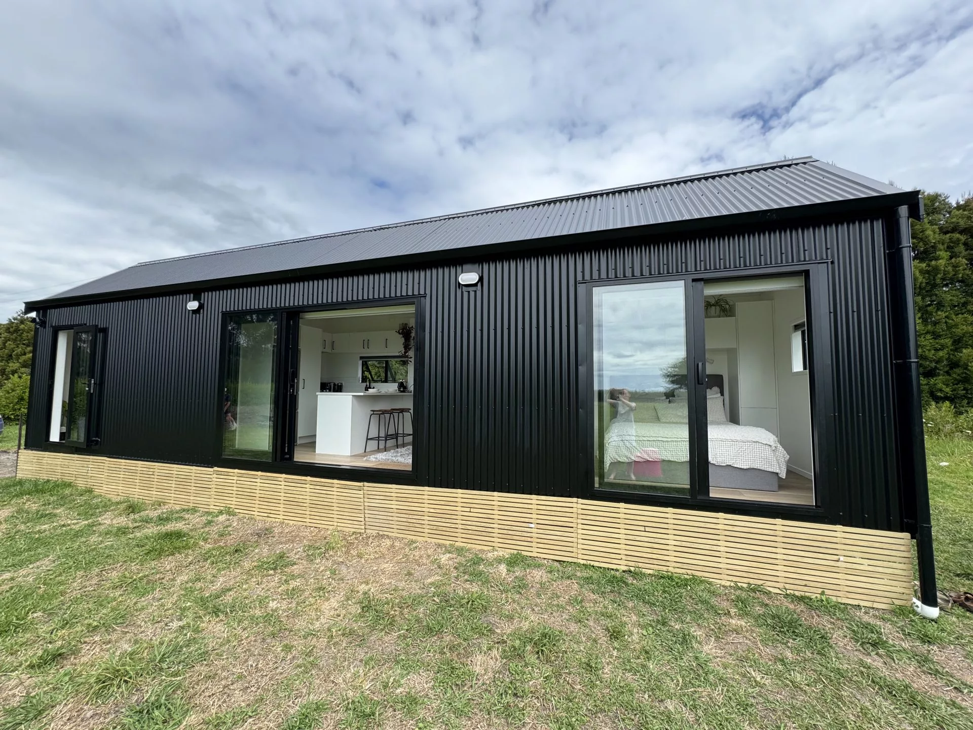 The Long Black (with loft) is a light-filled tiny house that includes two bedrooms and space for a home office