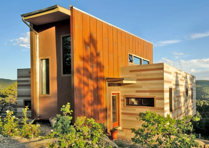 Two shipping containers flank the central living space on either side, and these make up the Shipping Container House's bedrooms and home office spaces