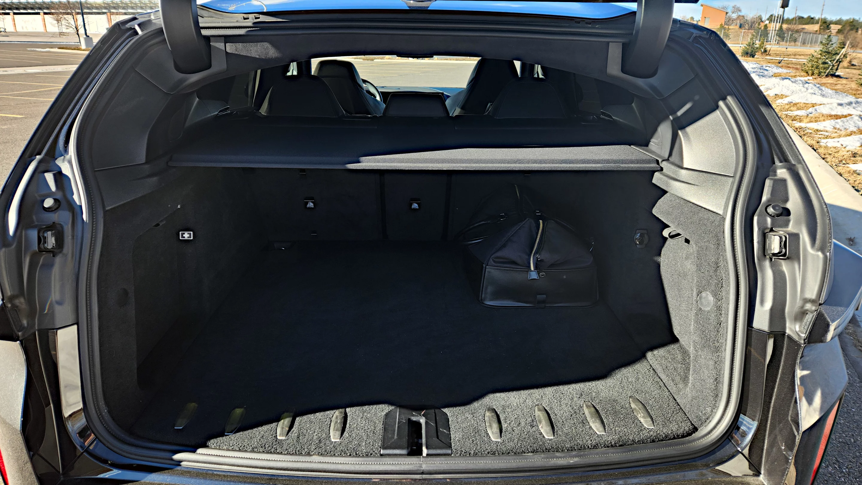 A cavernous cargo area contains a posh leather bag in which the plug-in cable resides