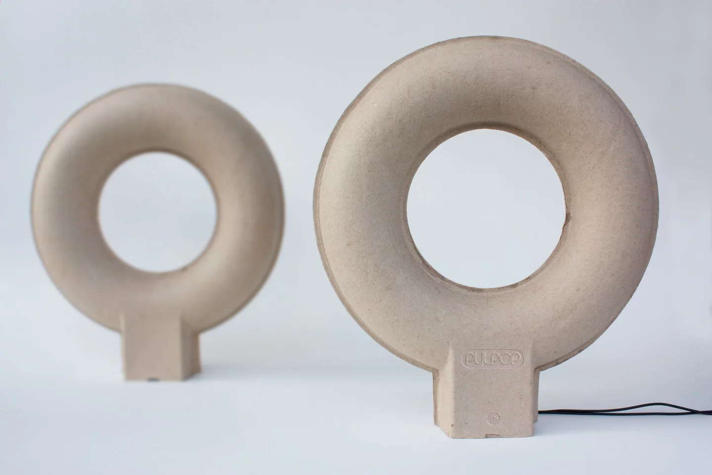 As sound doesn't usually travel well through paper, the hollow loop doughnut shape is said to provide enough surface area to distribute sound more evenly